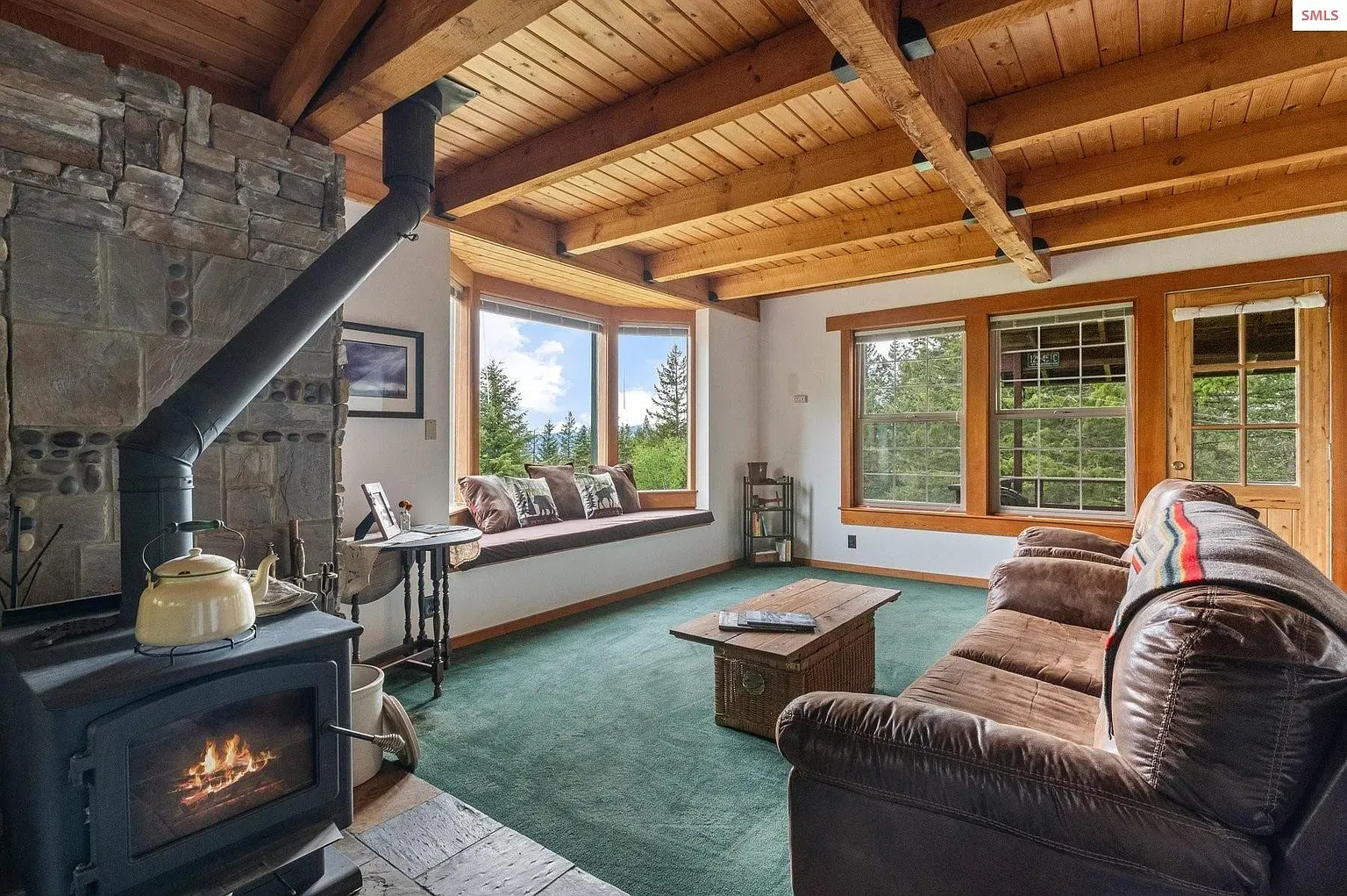 ## Chunky stone surround with a black stove—yeah, that's the cozy anchor here.