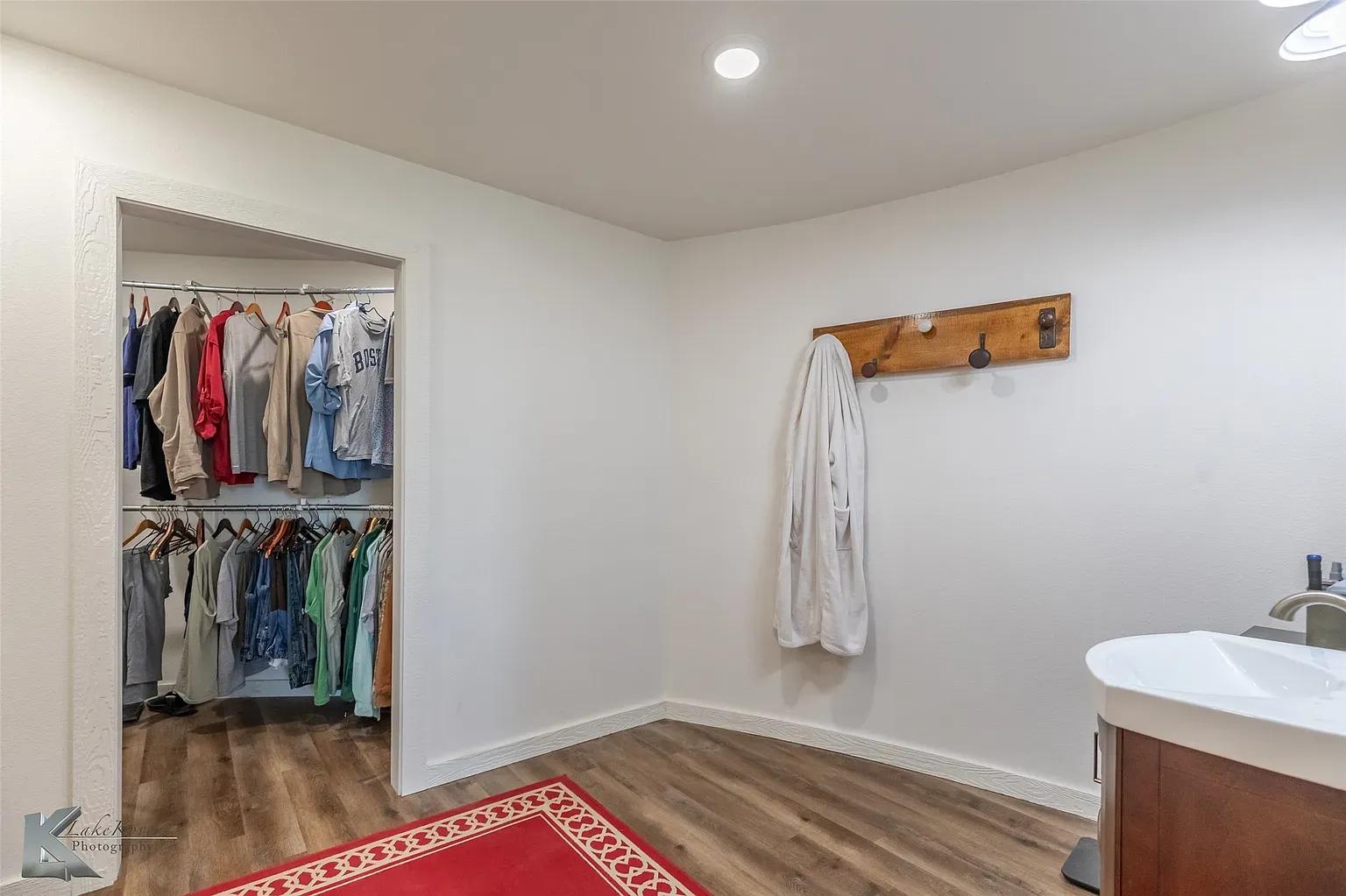 Little dressing nook—crisp white walls, warm floors, everything tucked neatly.
