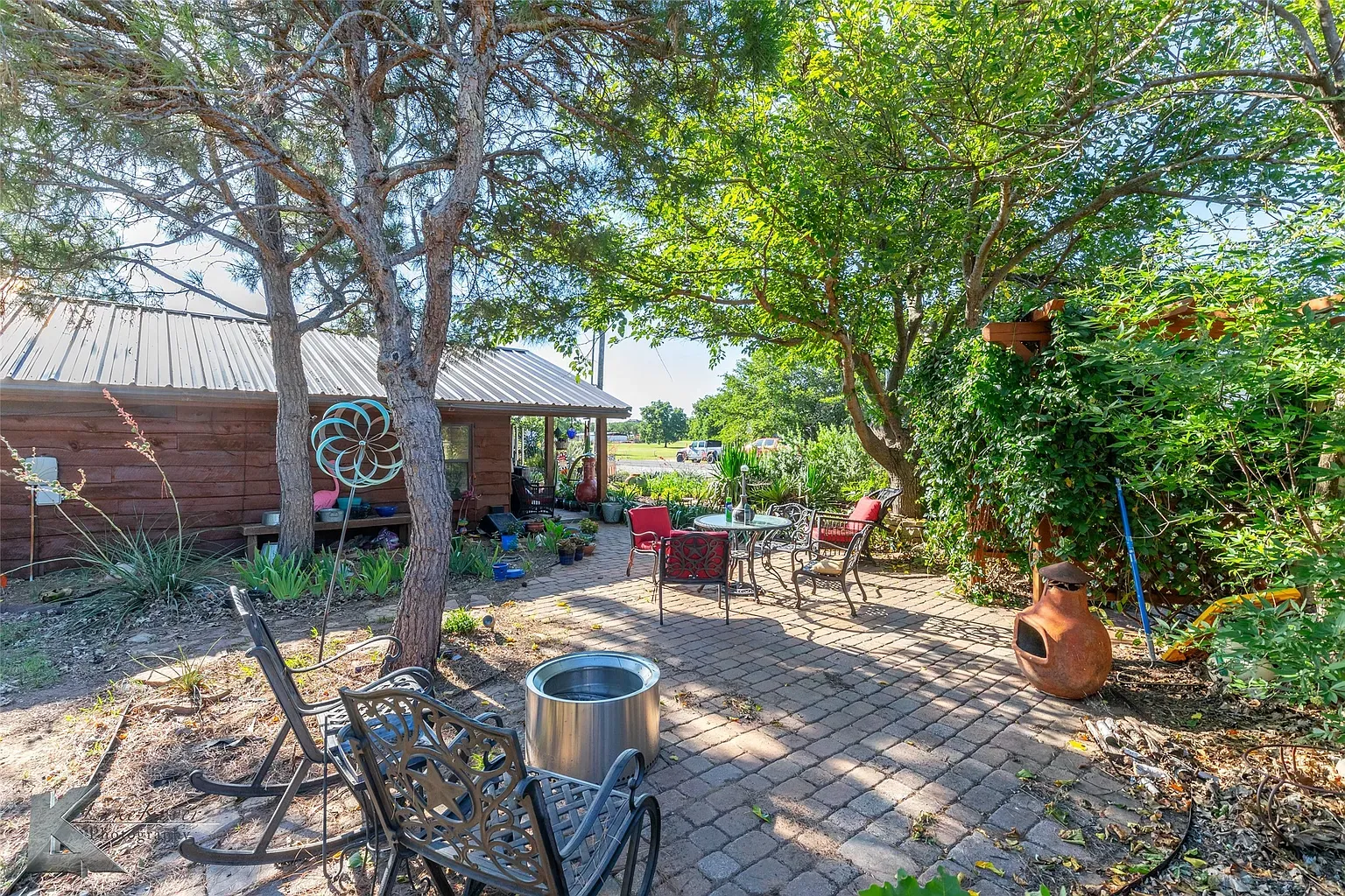 Patio's cozy. Brick pavers, iron chairs, lots of green. Easy weekend spot.