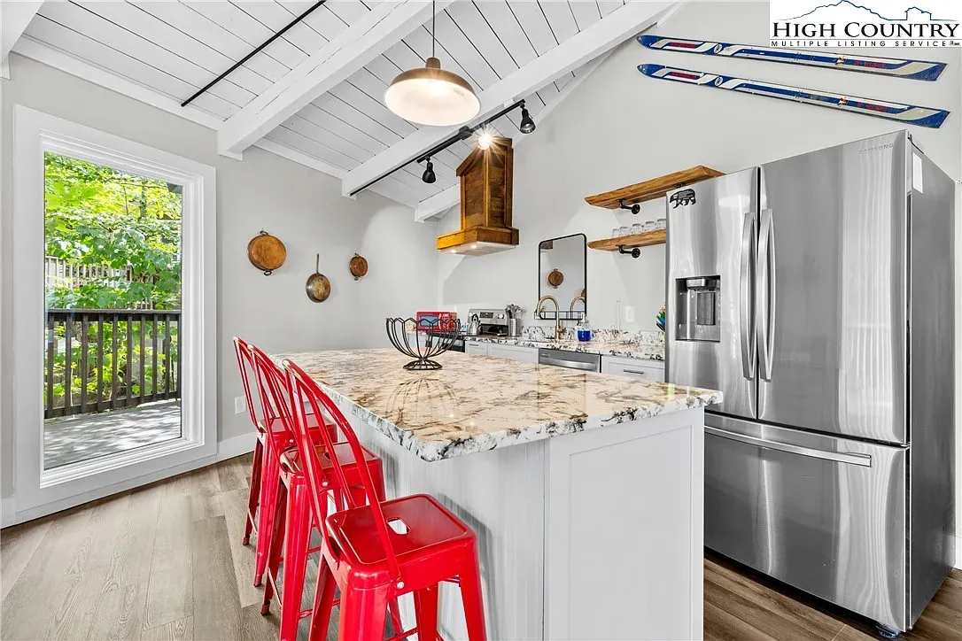 ## That island steals the show—speckled stone, earthy tones, and loads of prep space.