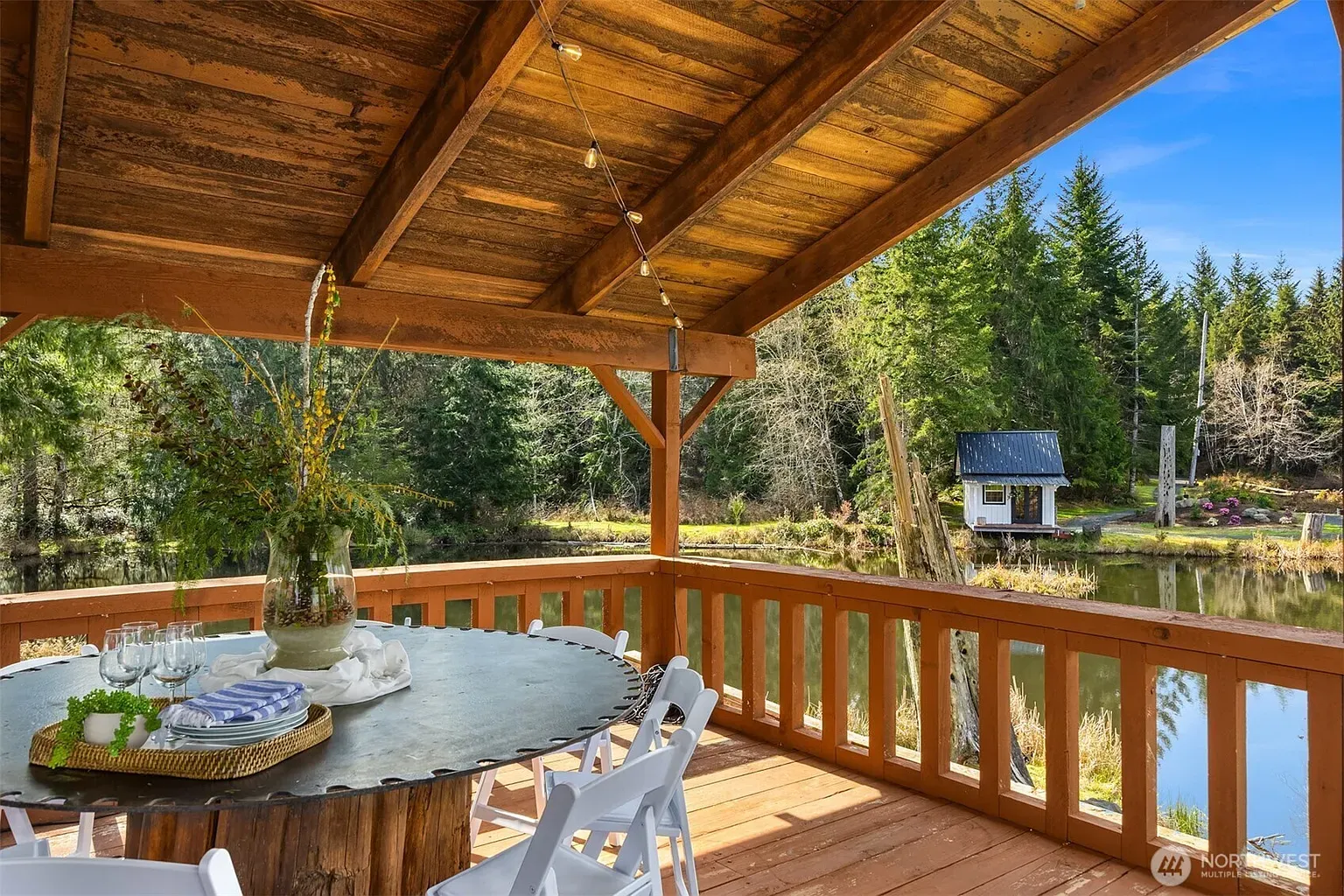 Outdoor dining under honey-toned beams — that round table could feed everyone.
