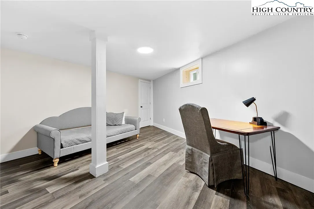 ## Calm neutrals and warm laminate create an easygoing zone for work, reading, or a quick nap.