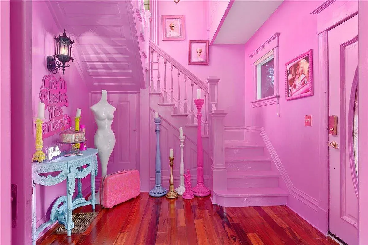 ## Final entry hall doubles down on pink; ceiling, walls, and staircase glow, with delicate detailing guiding the way out.
