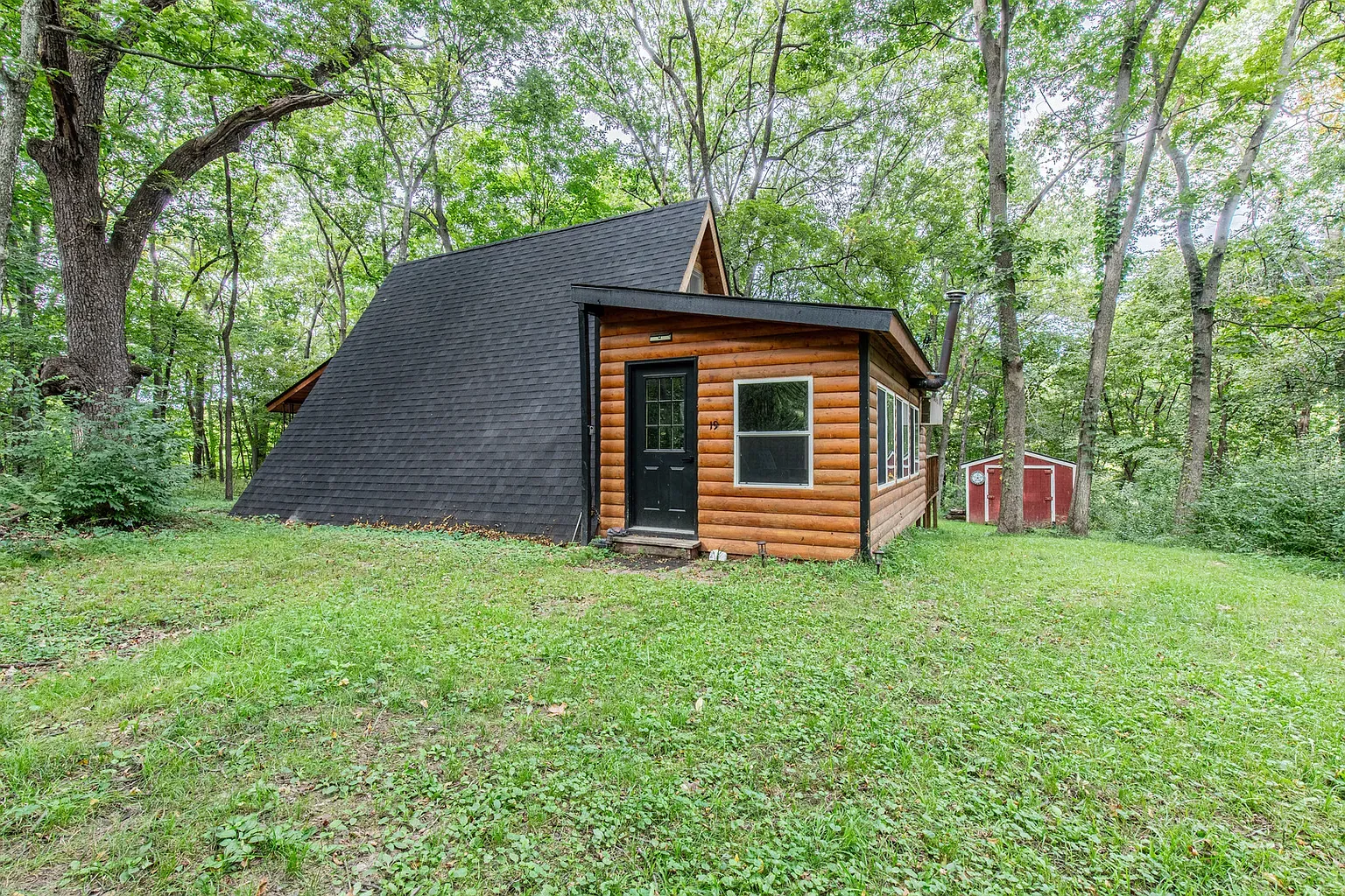Here's the A-frame — dark logs, bold entry. Amazing old woman energy.