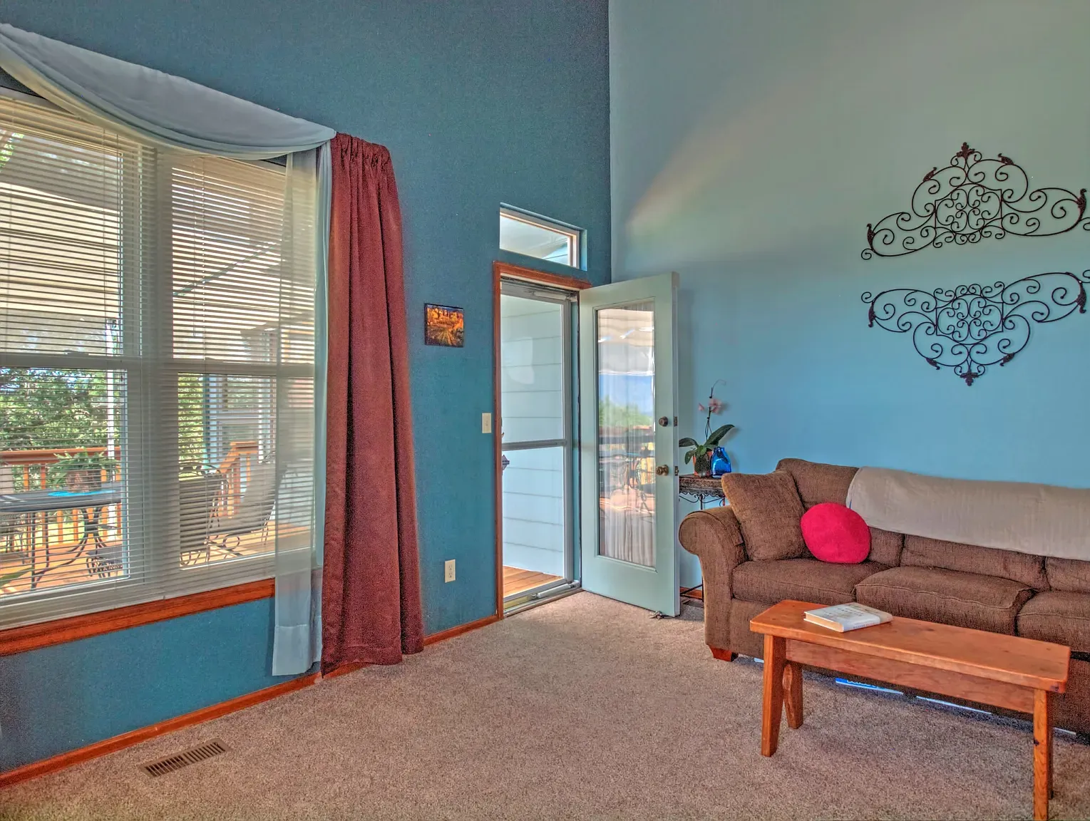 Soft blue walls, tall windows, comfy furniture. Airy room done right.