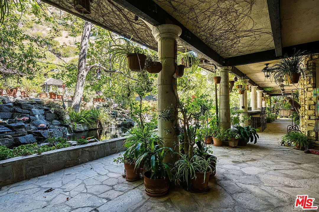 And then this loggia—stone columns, open ceiling, chunky flagstones. Breezy hangout.