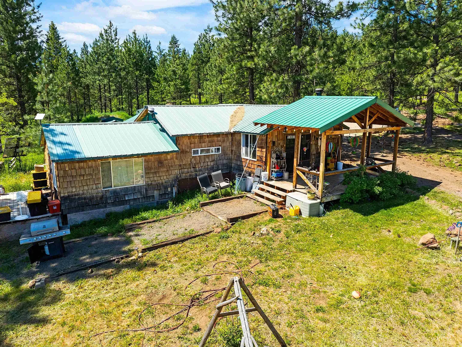 Rough wood siding with a bright turquoise metal roof.