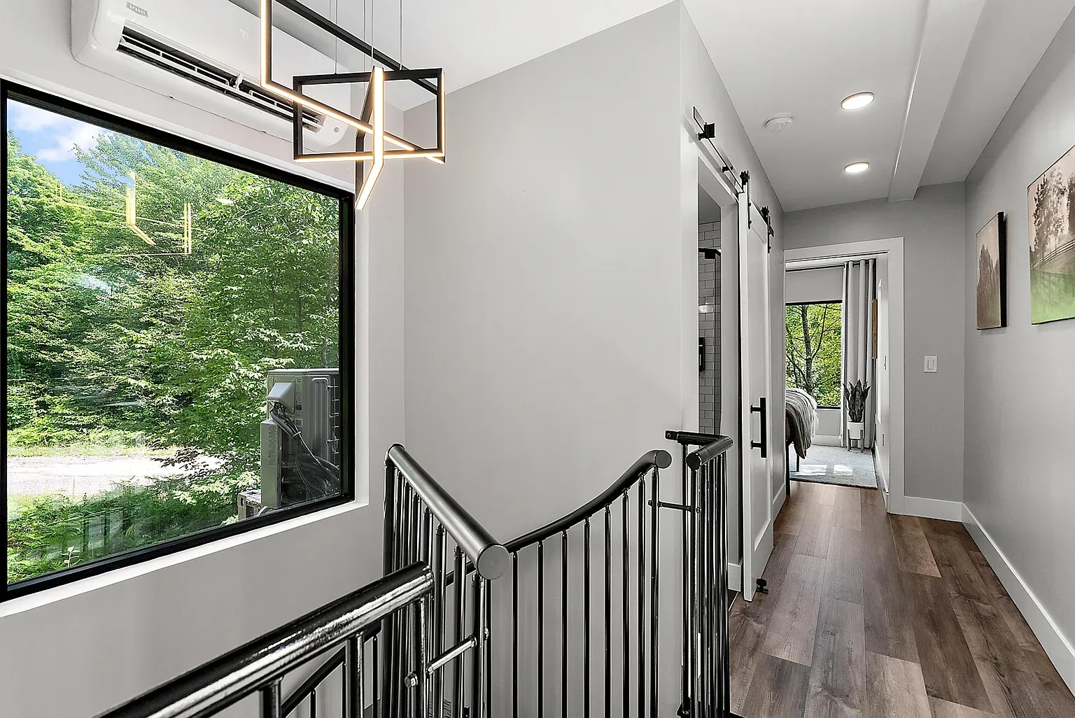 Hallway stays minimal, big window to the left pulling in forest light.