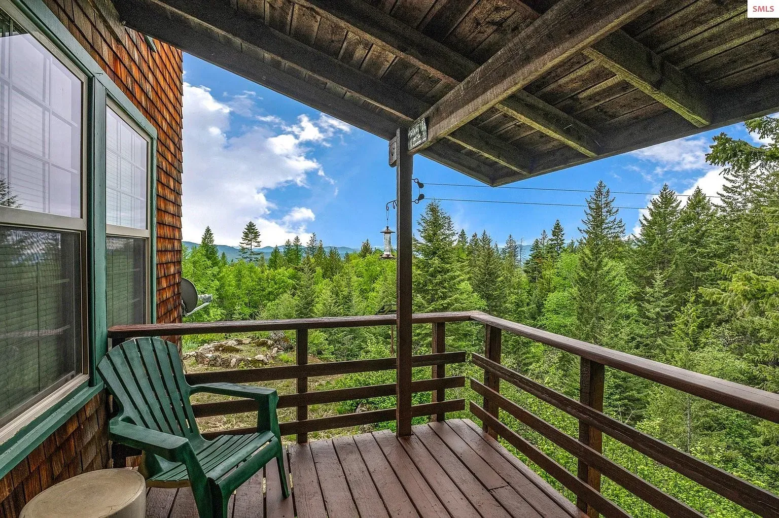 ## Dark railings, wood floor, lone green chair—forest view is pretty sweet.