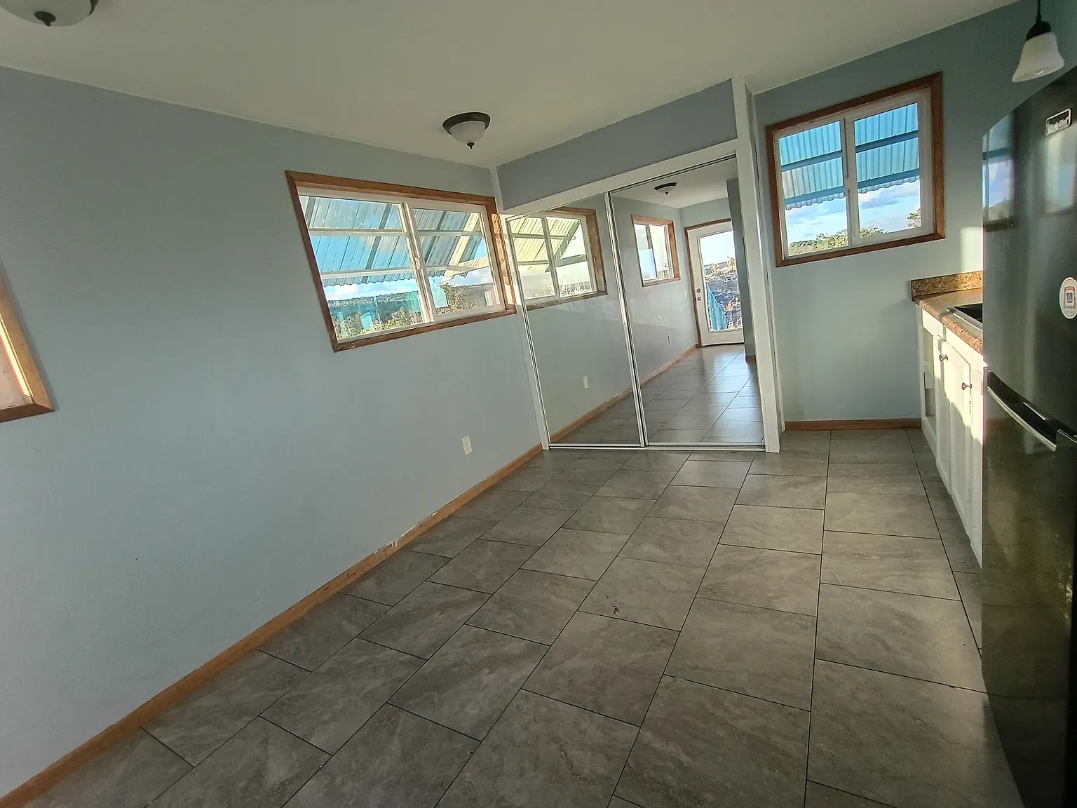 Living space feels airy. Blue walls with warm wood trim actually hit.