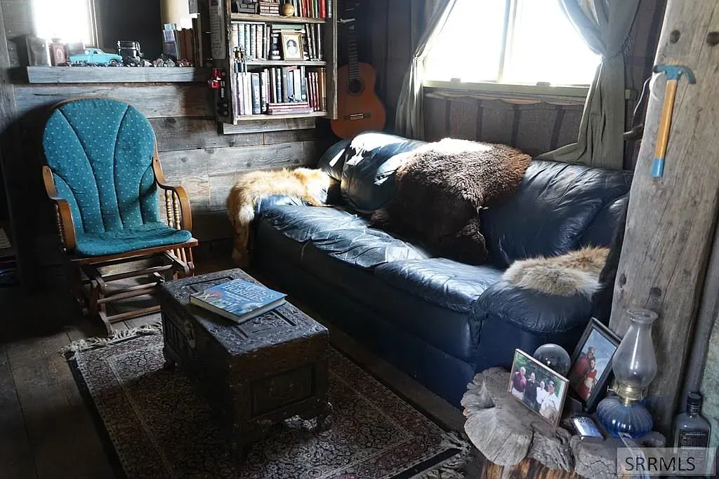 "Here’s a comfy little spot to unwind—love how the couch invites you to kick back! And check out that fun rocking chair over there, perfect for relaxing with a good book. The mix of books and decorations on the shelf creates such a