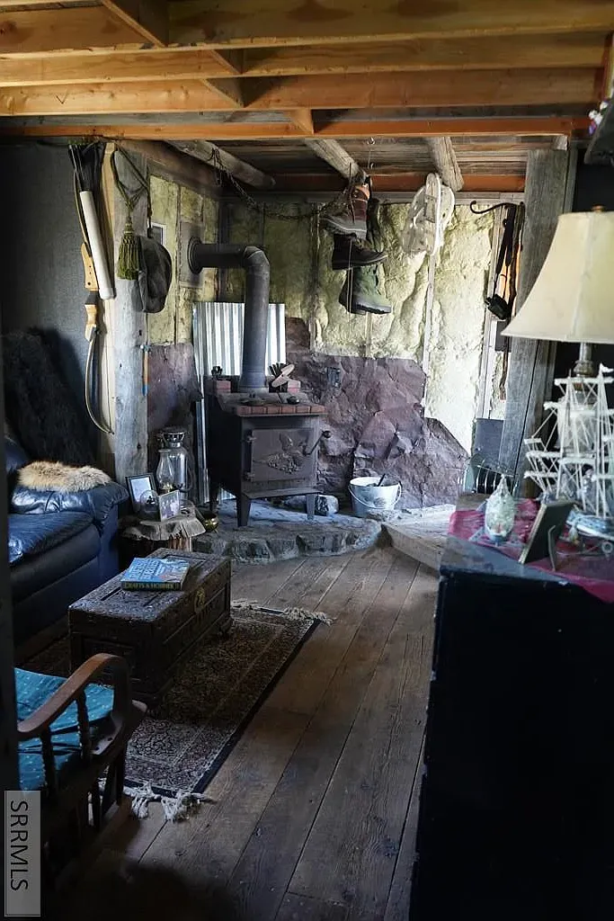 "You'll love this charming little nook! The stone wall really adds character, and there's a cozy wood stove perfect for chilly evenings. Plus, that rustic ceiling gives it such a warm vibe. It's a perfect spot to curl up with a book!"