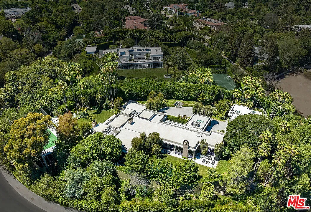 From this angle, flat-roof estate tucked in greenery. Low, wide, intentional.