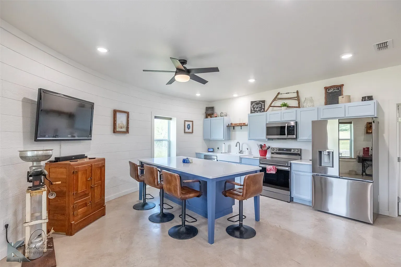 Center island steals the show. Blue cabinetry keeps it friendly.