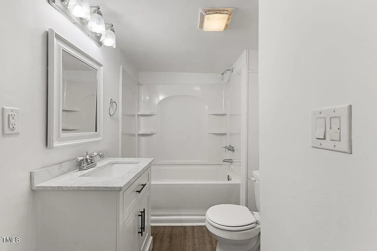 ## The bathroom goes bright and crisp: white finishes, soft-close vanity, and a polished counter that looks like quartz