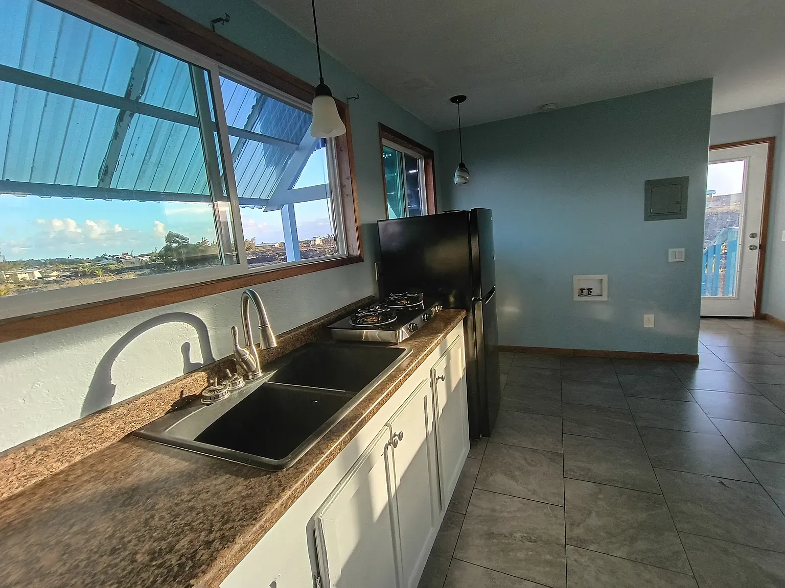 Kitchen’s soft blue walls plus that huge window — super calming, nice light.