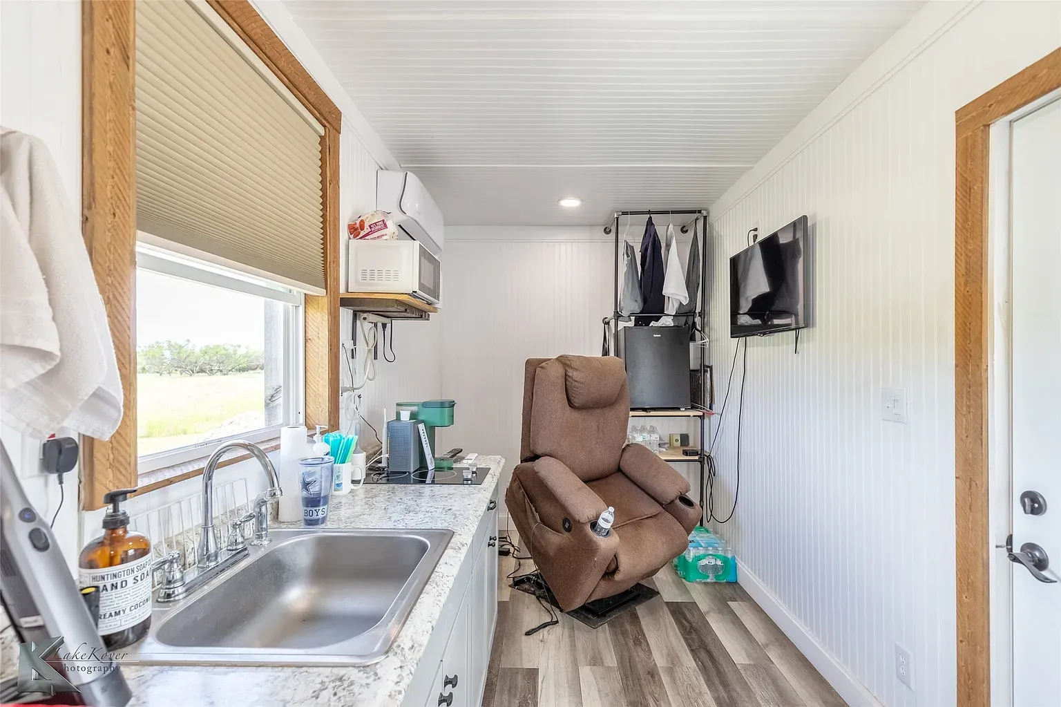Inside, white paneling and warm window trim. Compact, bright, surprisingly cozy.