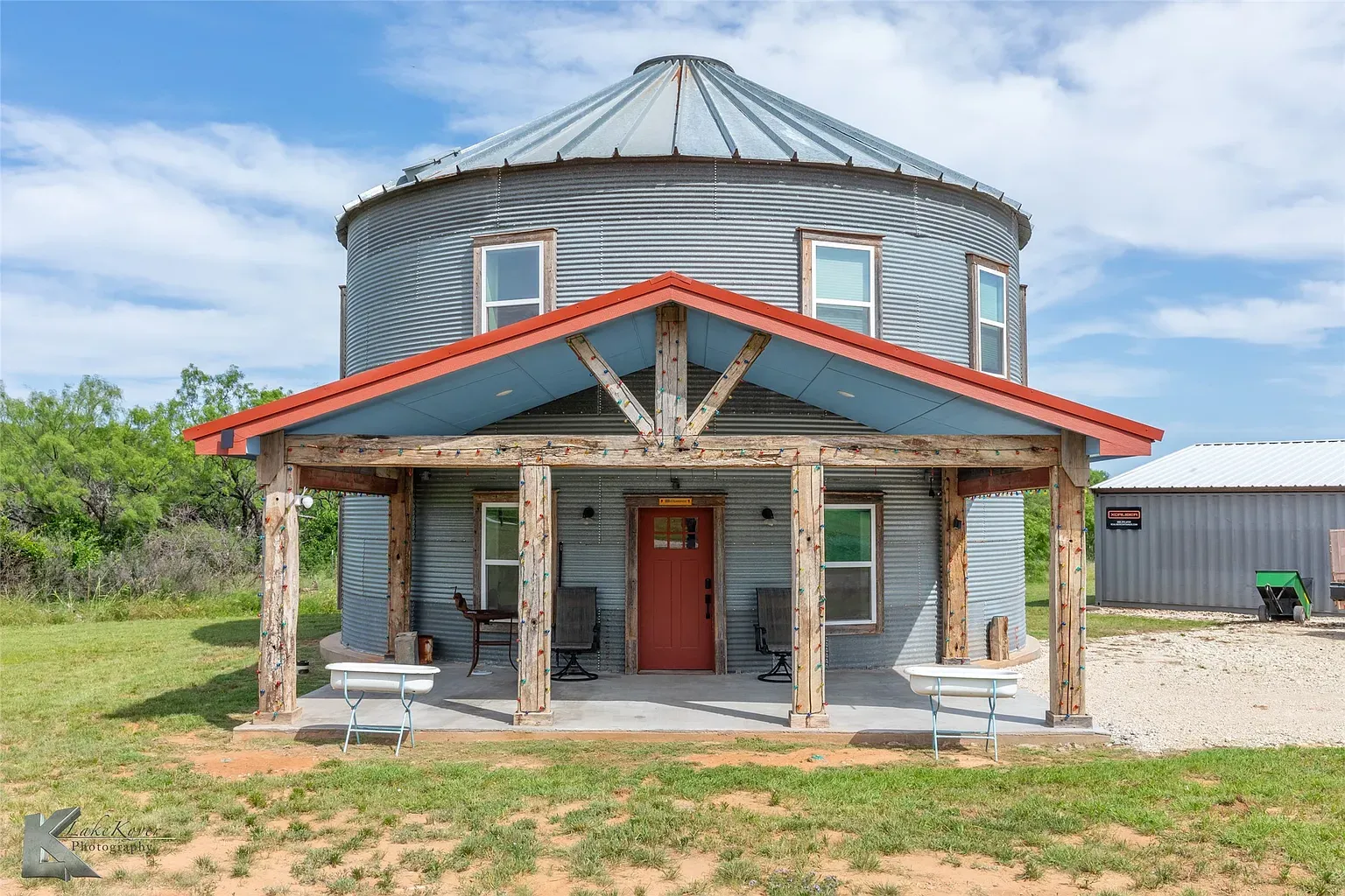Back outside—round corrugated exterior with a porch. Would you actually buy this?