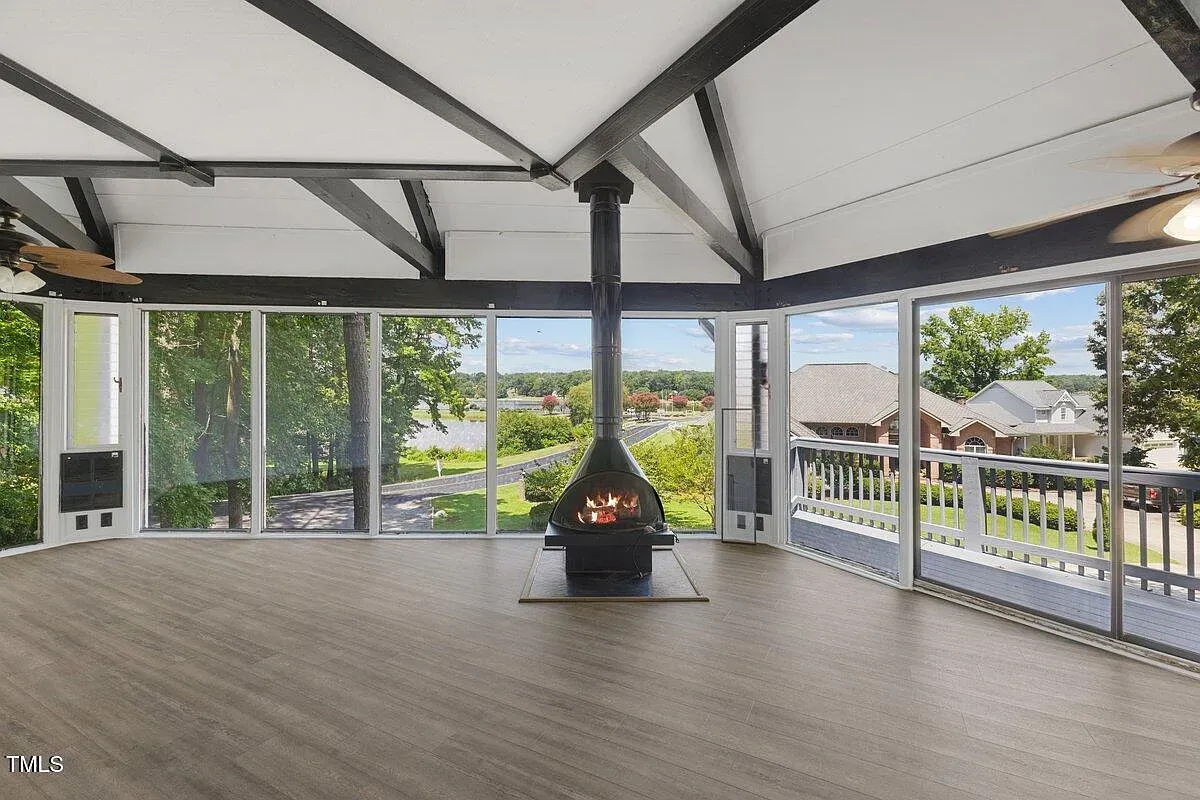 ## The lounge frames the landscape, while a sleek black cylindrical fireplace anchors the space. Honestly, it’s a showstopper