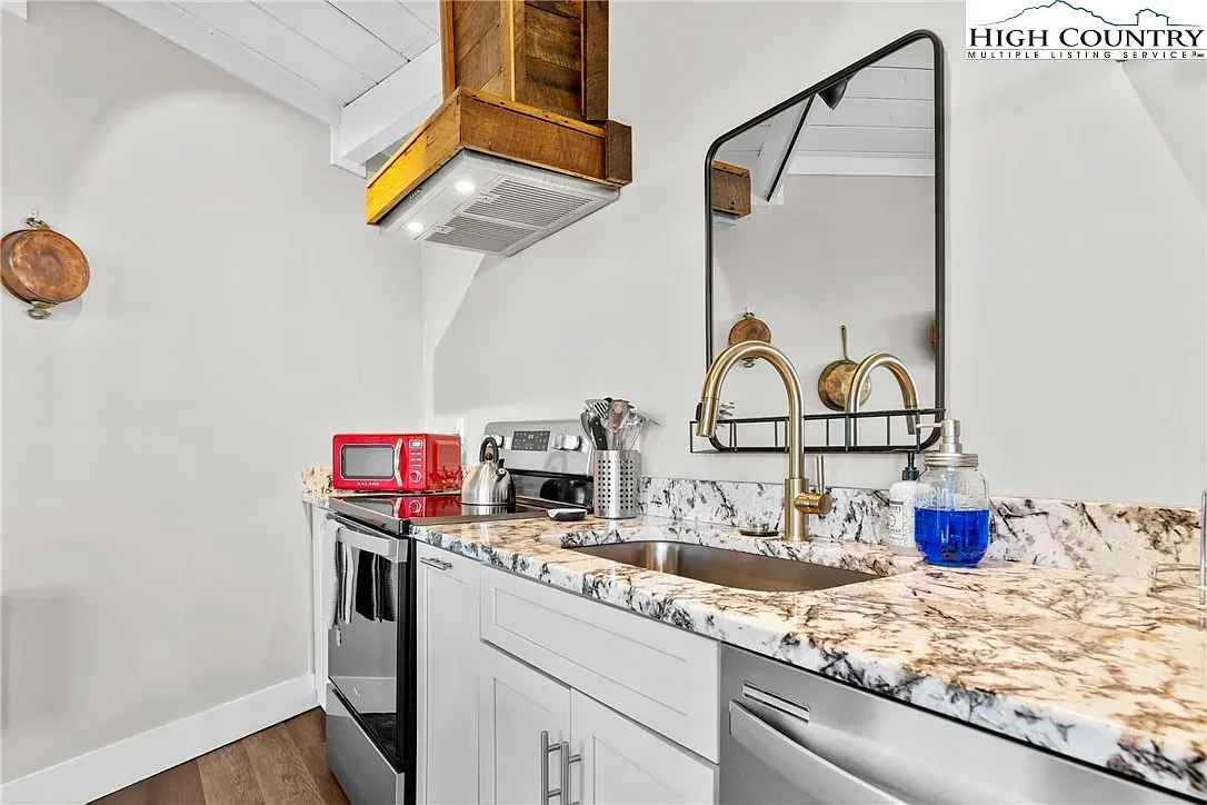 ## The kitchen has great natural light, white cabinets, and granite that mixes creamy whites with deep browns.