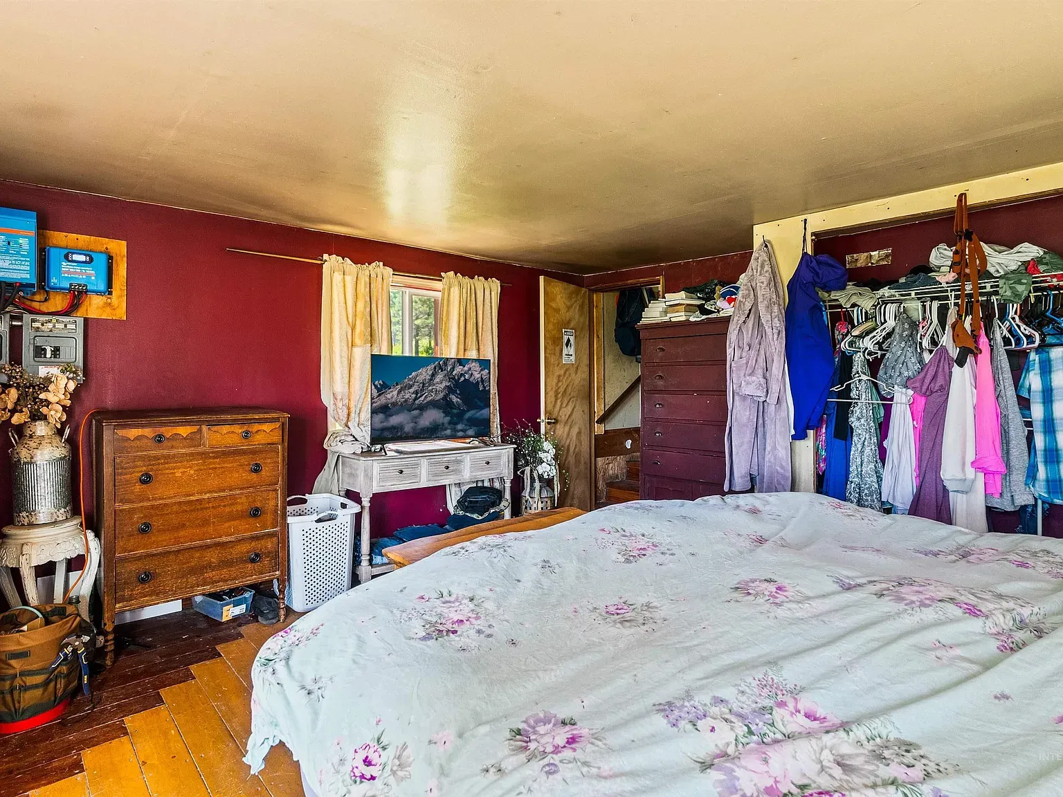Deep burgundy walls with soft floral bedding. Kinda sweet.
