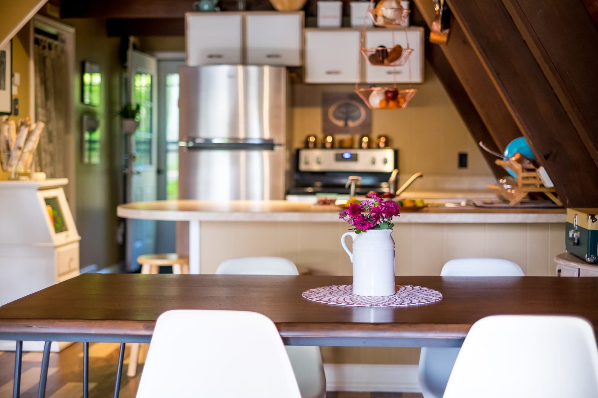 "Cozy A-frame kitchen with charming floral touches and modern finishes!"
