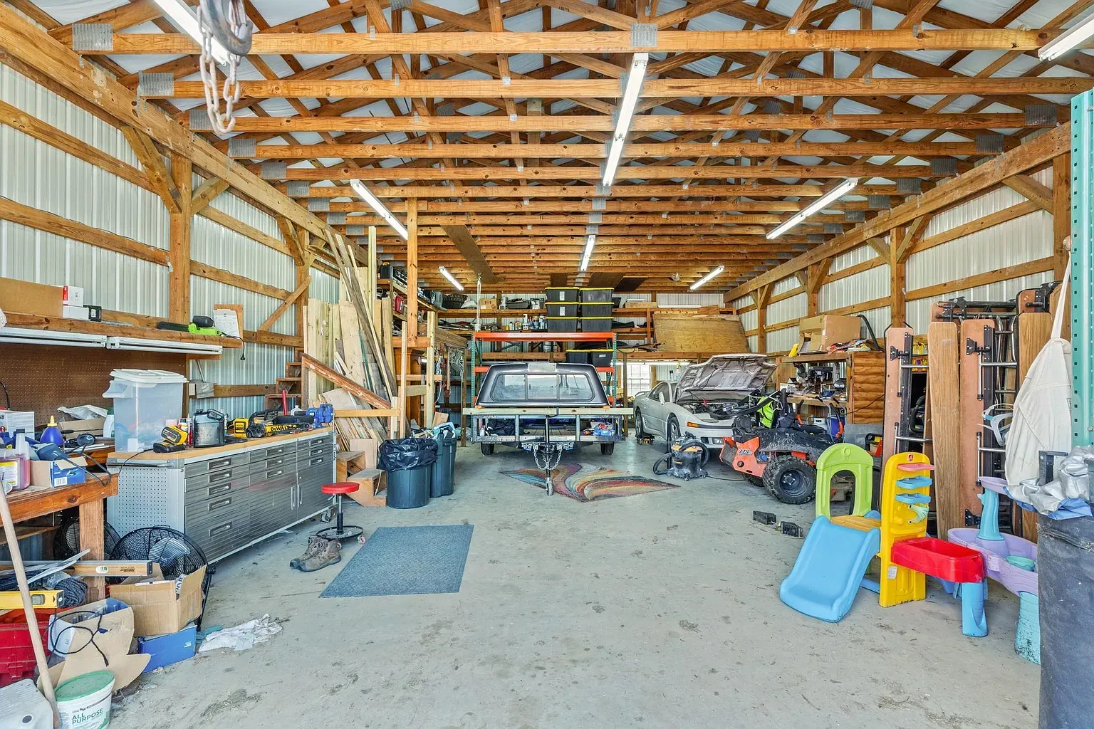 Garage goals. open beams, huge windows, everything neatly parked and shelved.