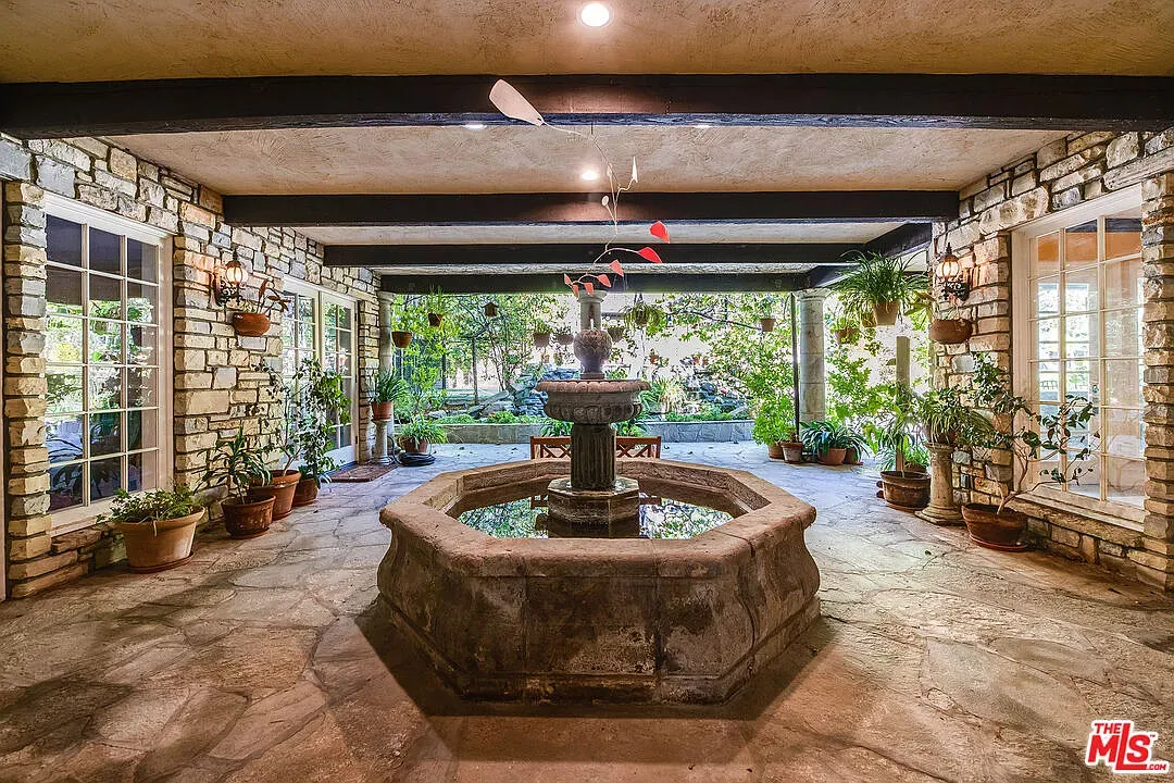 Courtyard fountain doing gentle ASMR. Pots and vines everywhere, super calm.
