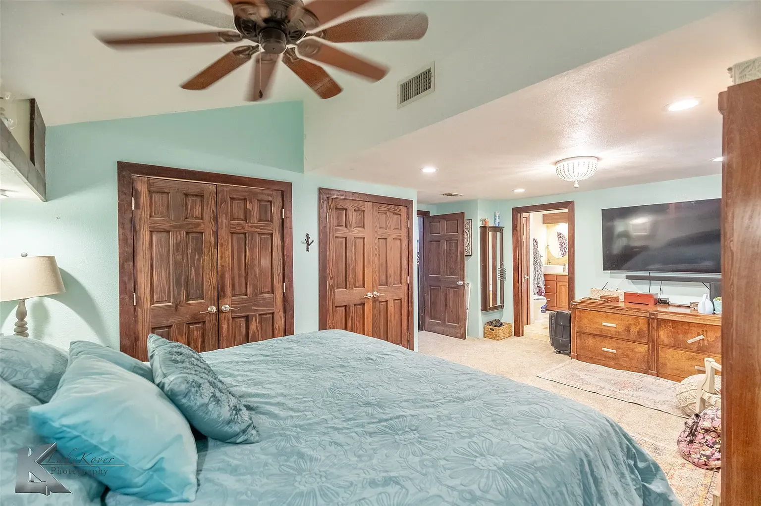 Blue bedroom time. Aqua walls, fluffy bed, very rental-listing pleasant.