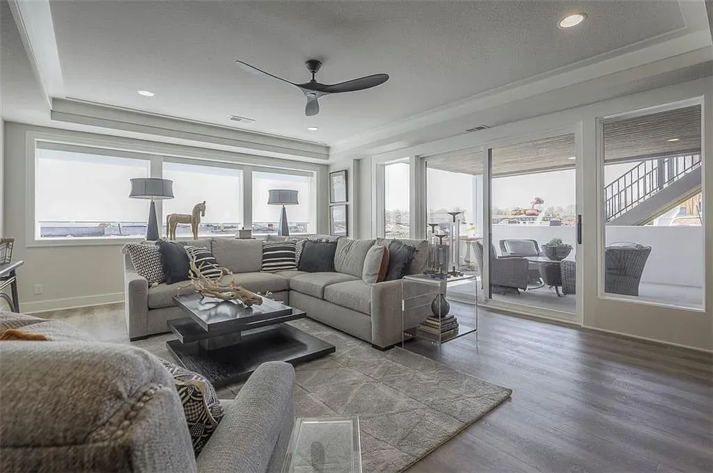 Here's the living room—huge windows, soft gray sectional, easy hangout zone.