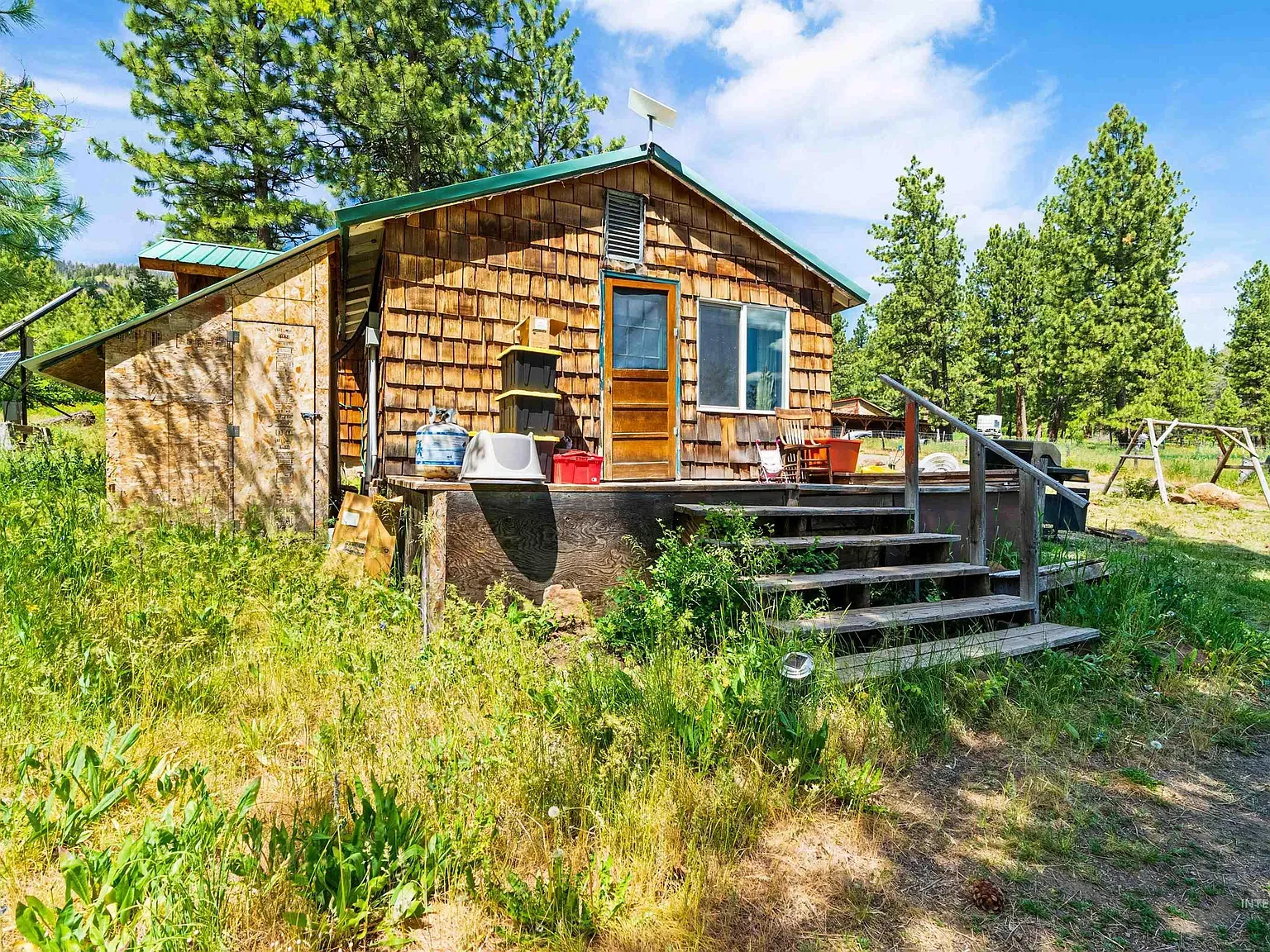 Cedar shakes on the walls, low green metal roof.