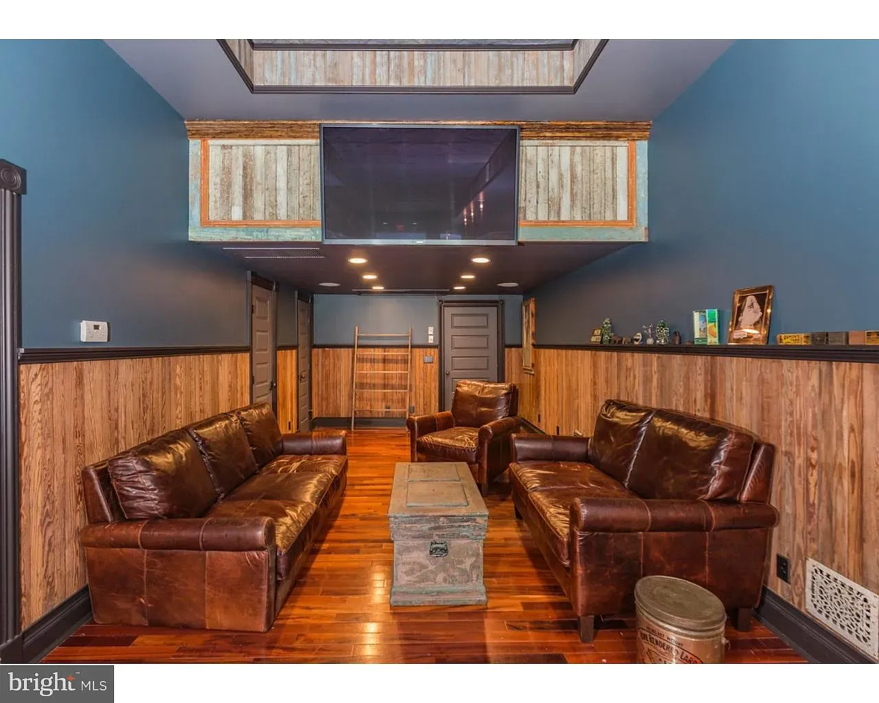 Deep blue walls over wood paneling—feels cozy, not cave-y. I dig it.