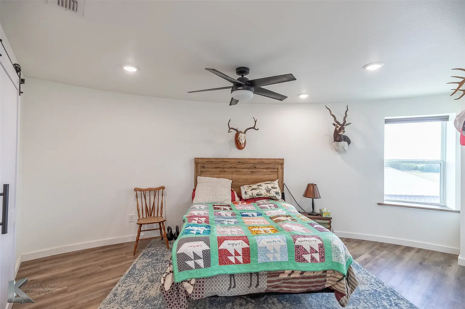 Cozy bedroom with a patchwork quilt and wood headboard. Feels cabin-y.
