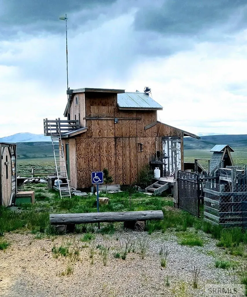 "Here’s the back view of the house—it’s got that rustic charm and plenty of space to explore! I love how there's a little ramp for easy access and the ladder leading up to the deck for some awesome views. You can really soak in