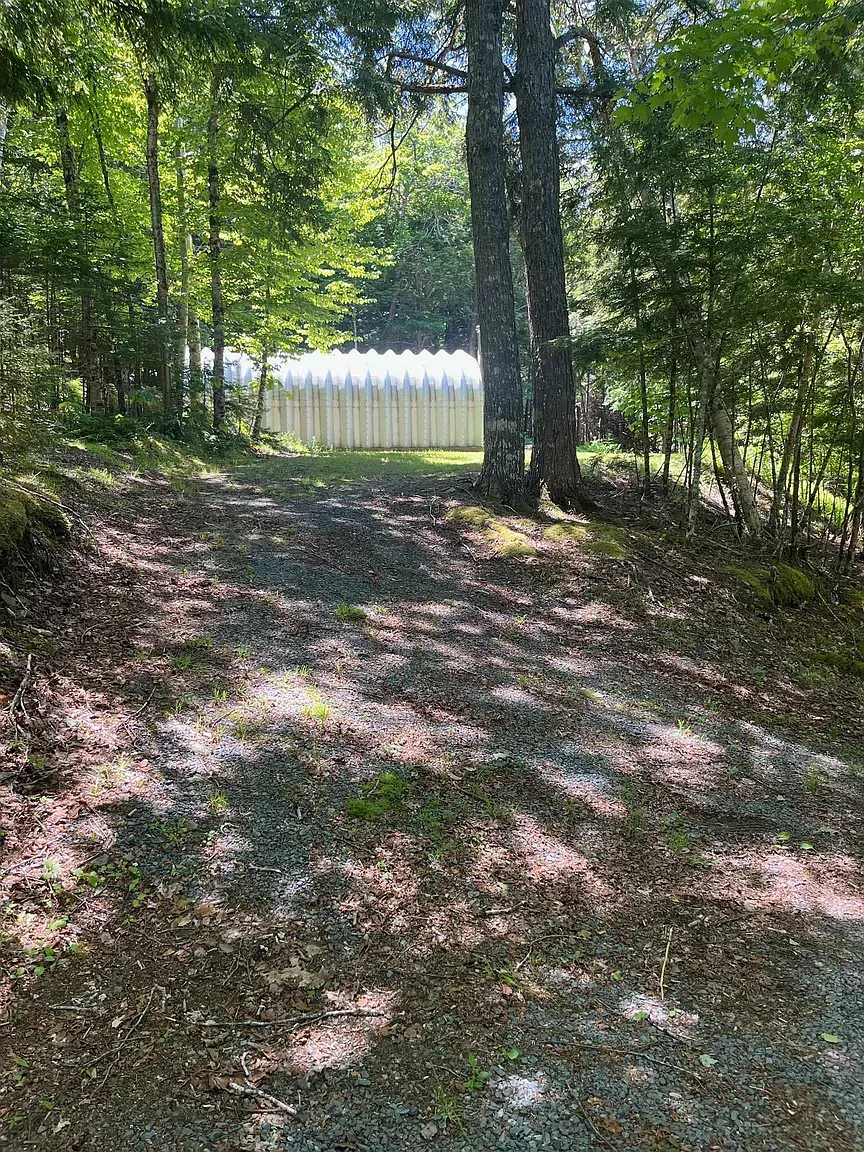 Path rolls in quietly. Gravel, moss, dappled light. Greenhouse peeking it knows.