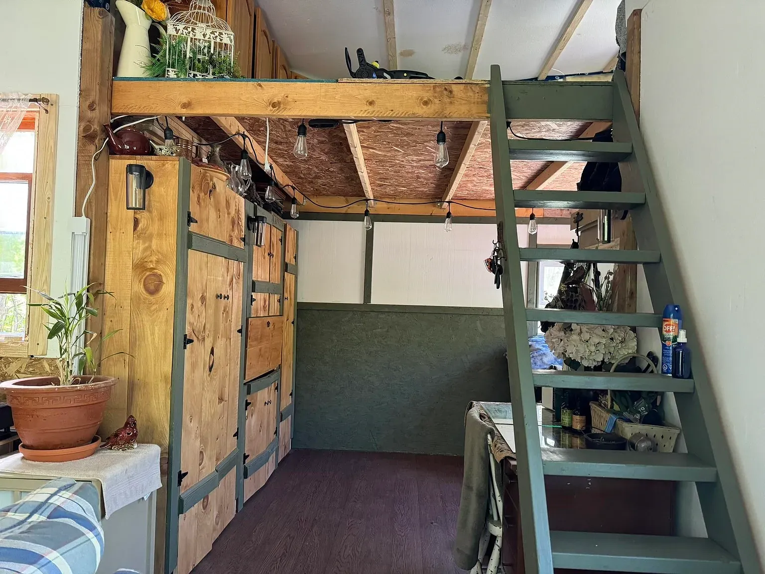 Inside, loft tucked up top. All wood, golden, cozy, not claustrophobic.