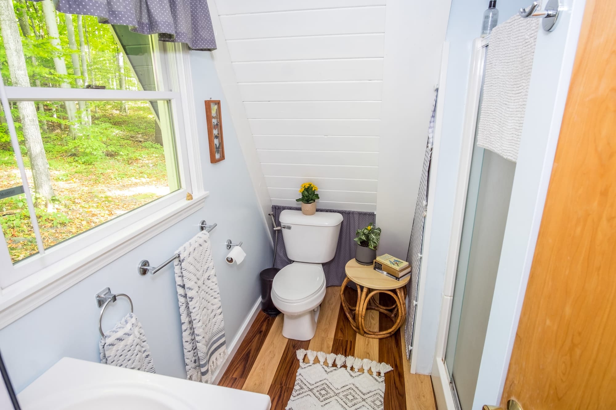 "Bright bathroom with forest views and charming natural touches!"