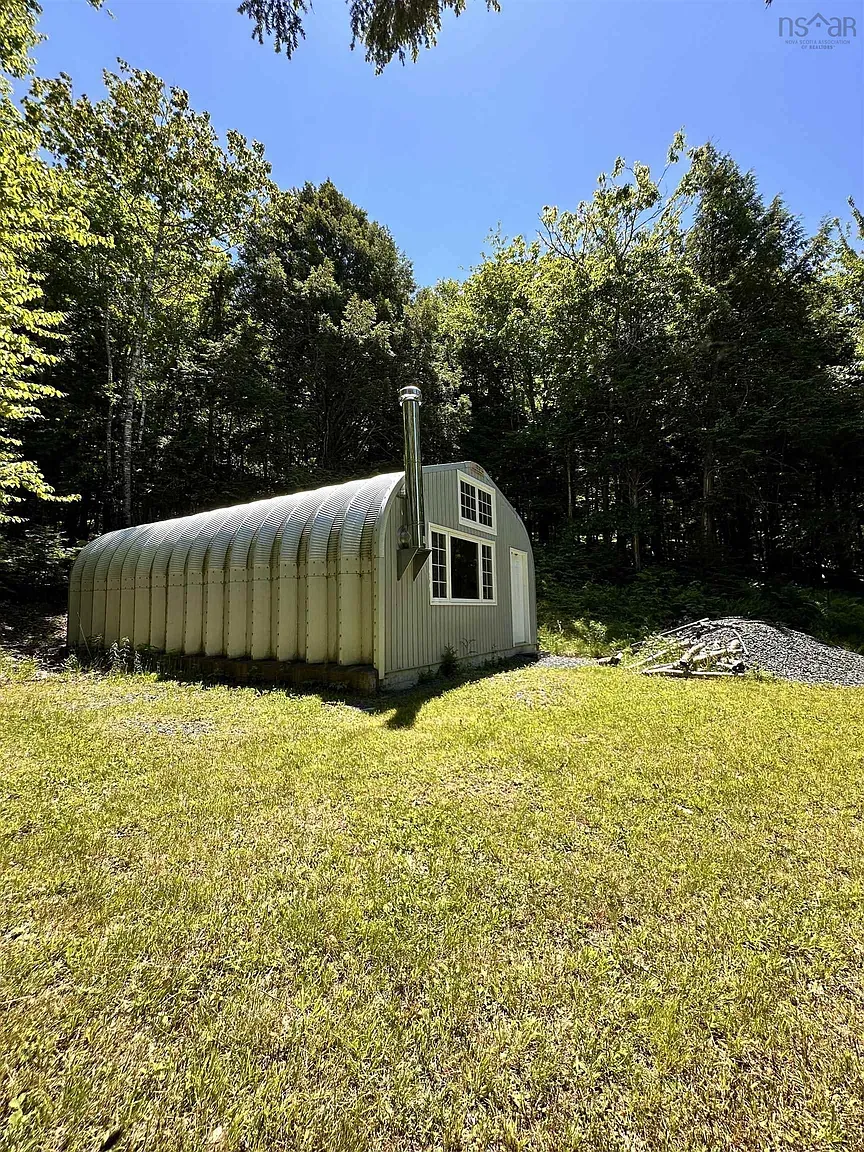 Here’s the exterior — arched Quonset vibes, green and silver metal. Kinda charming.