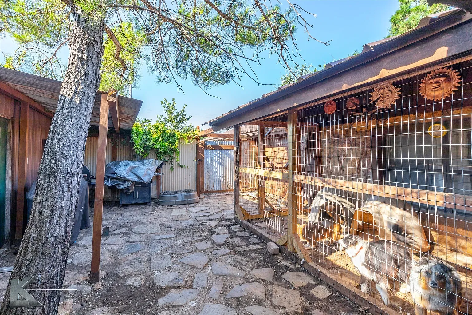 Courtyard goes full cottage-core. Are those little animal pens or art?