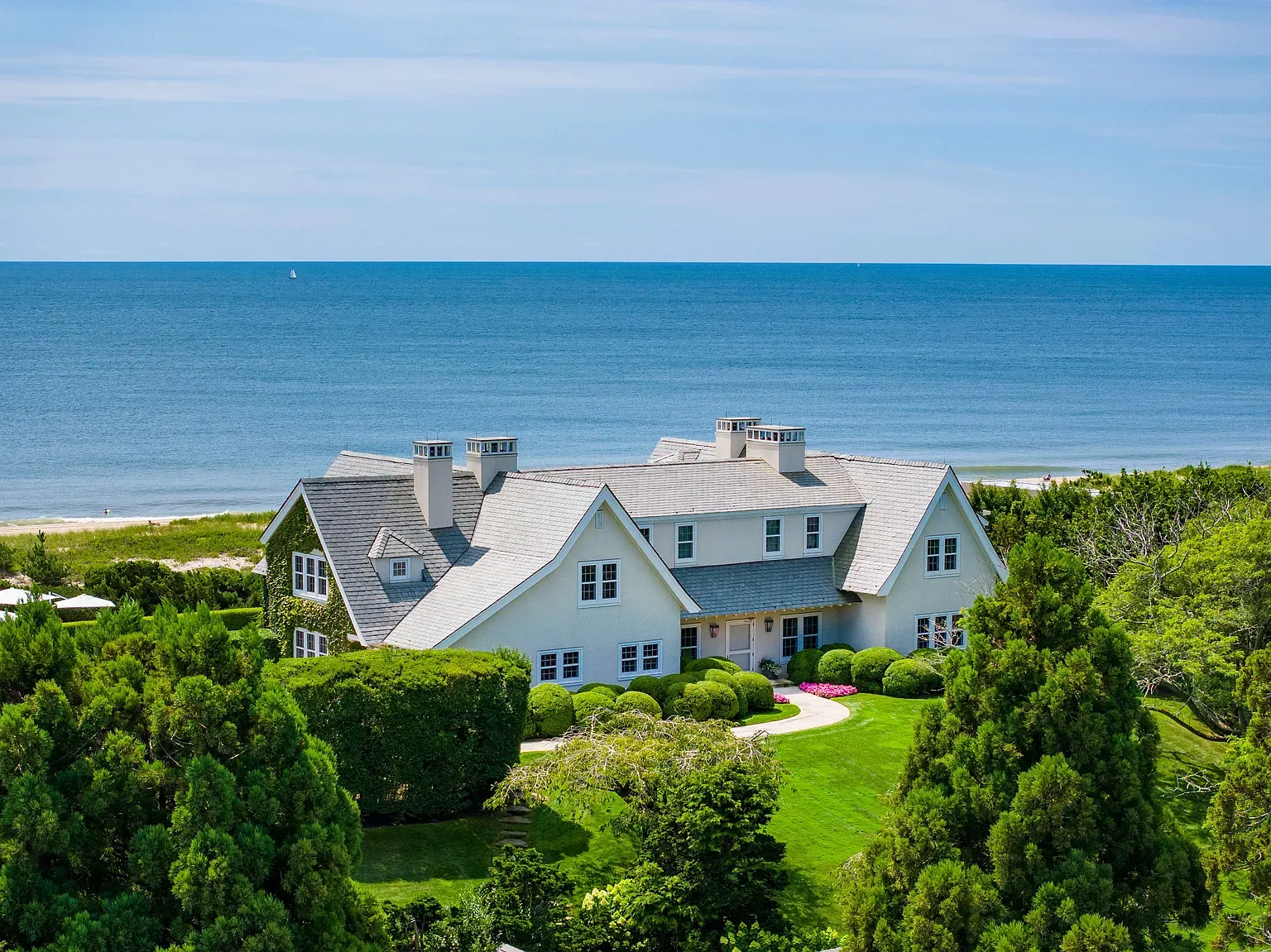 "Take a look at this lovely seaside home! You can see the ocean just beyond the trees—what a fantastic spot to relax!"