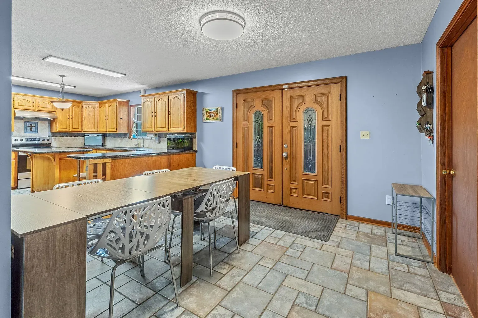 Here's the kitchen — blue walls meet honey cabinets. Classic, cozy combo.