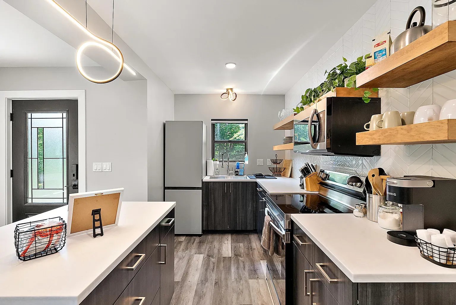 Here's the kitchen — dark cabinets, white quartz. Anyone know the wood species?