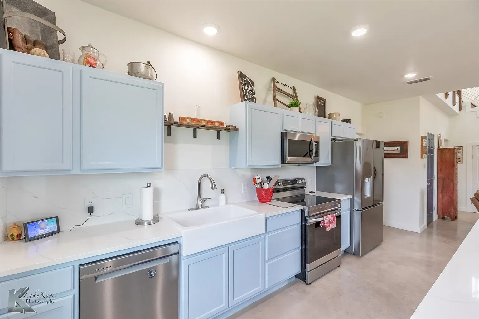 Another kitchen angle—pastel blue cabinets, quartz tops, big farmhouse sink.