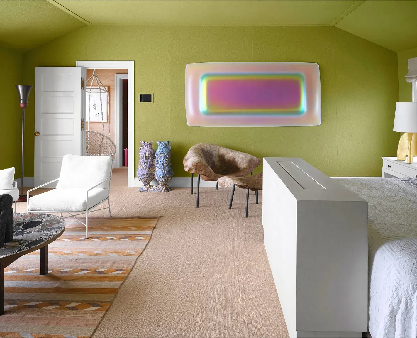 "This room has such a unique vibe with that bright green wall and that cool artwork! I love how open it feels with all the natural light coming in. The chair over there looks super comfy, perfect for curling up with a book. Plus, it