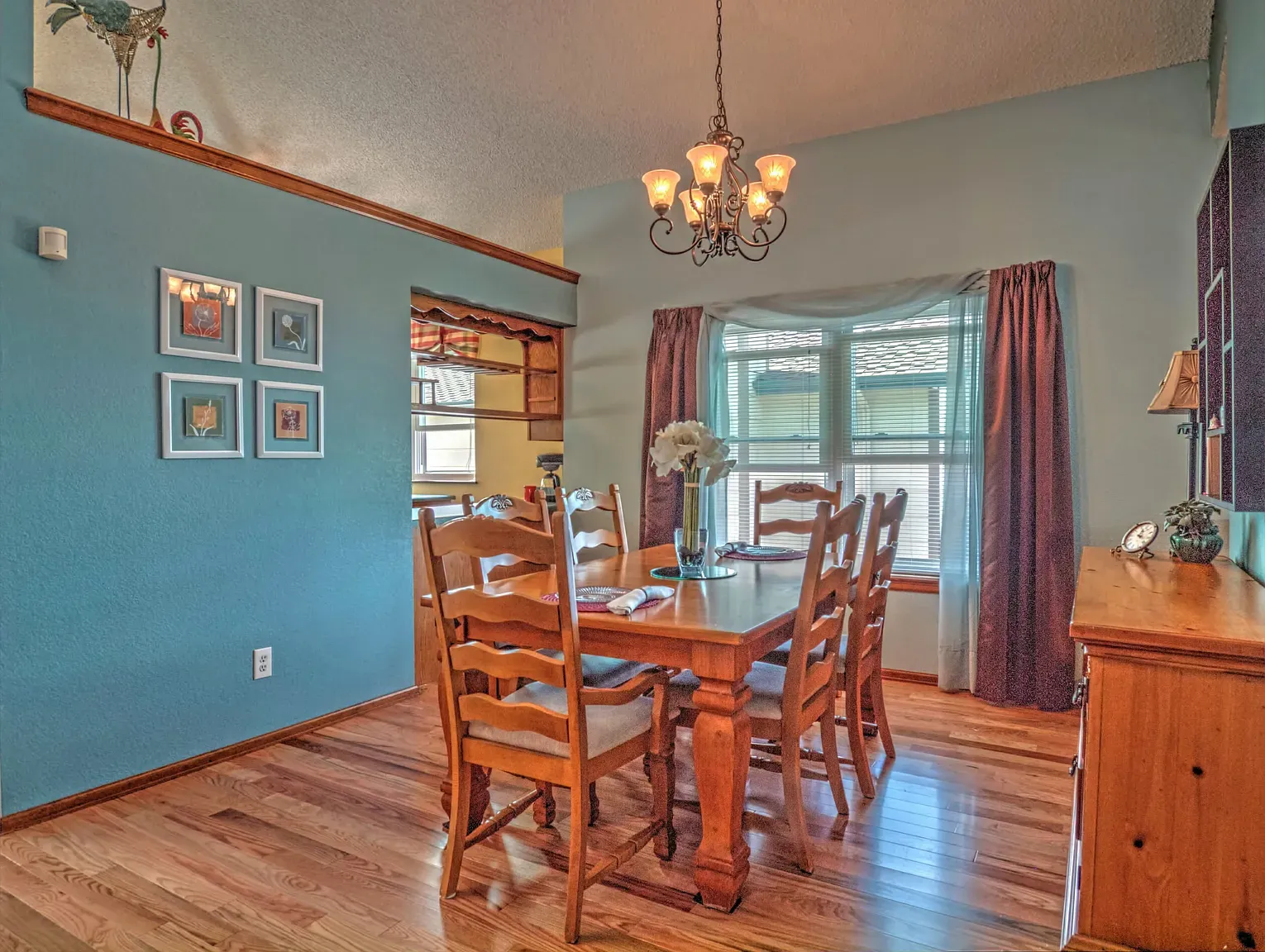 Final dining room — soft blue and honey wood. Simple, warm, looks lived-in.