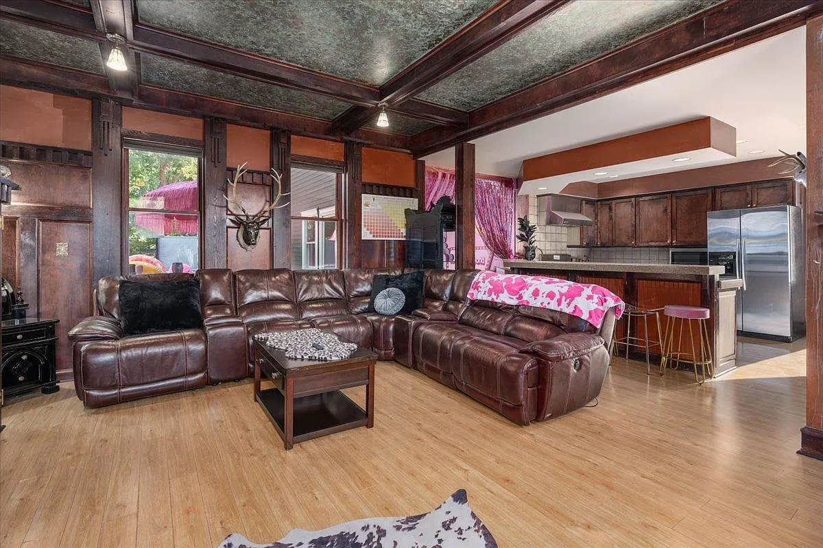 ## Living room shifts to rustic comfort: a huge dark leather sectional and warm wood details make it easy to settle right in.