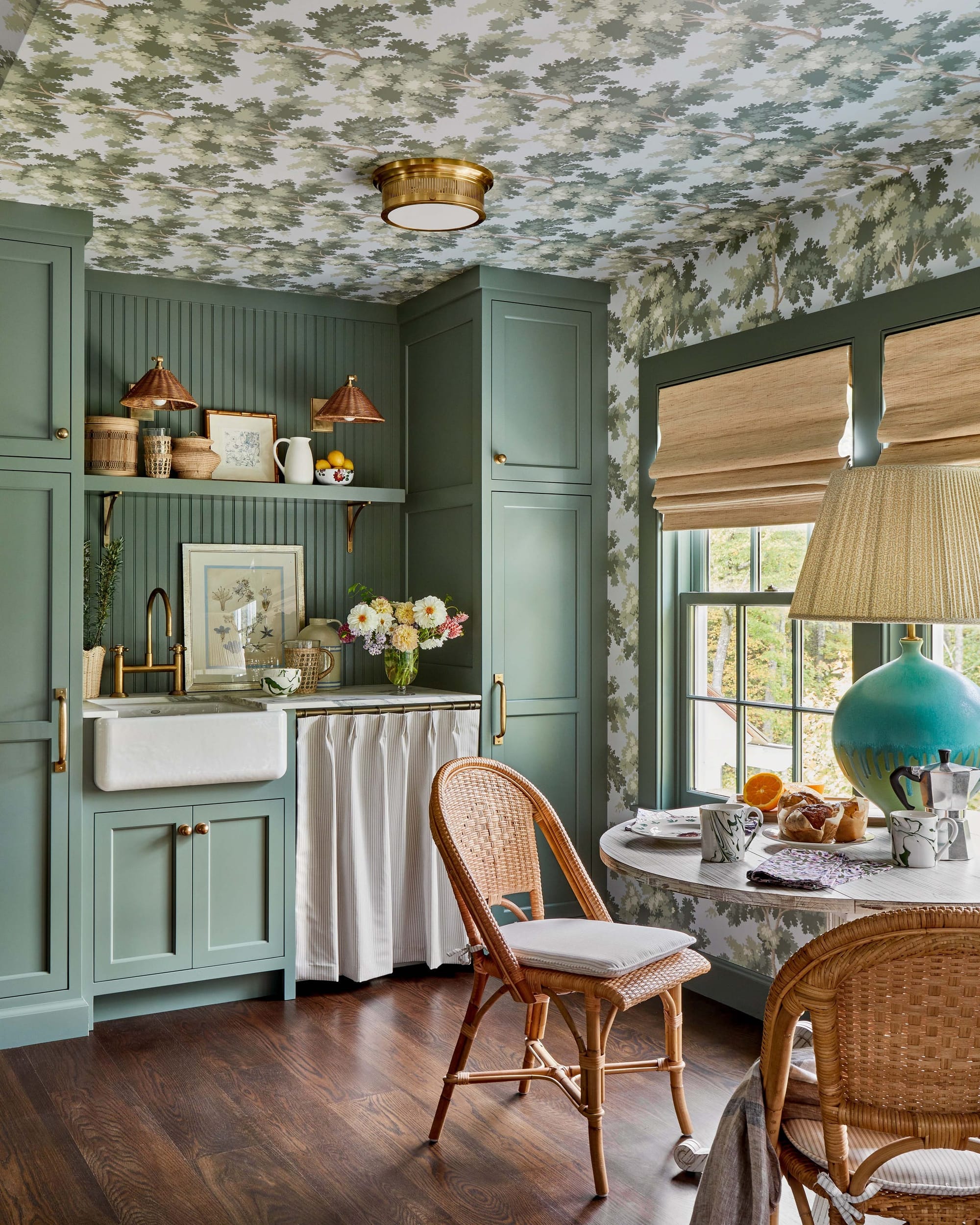 "This charming cottage kitchen blends whimsical treehouse vibes with sage cabinetry and natural textures for the perfect cozy breakfast nook!"