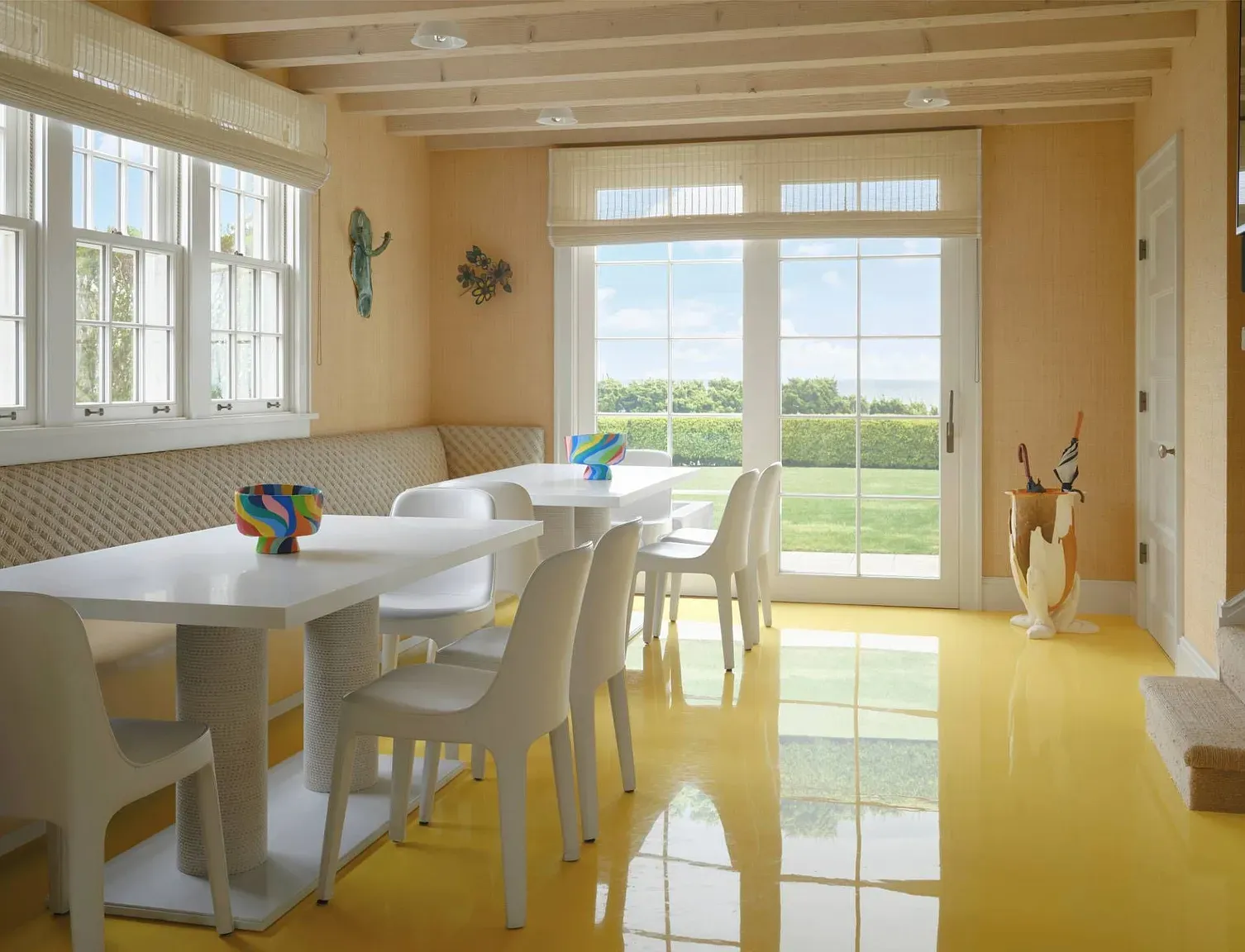 'Here’s the breakfast nook, and it has such a nice view of the backyard. The yellow floors really brighten the space, don’t you think? Perfect for morning coffee!'