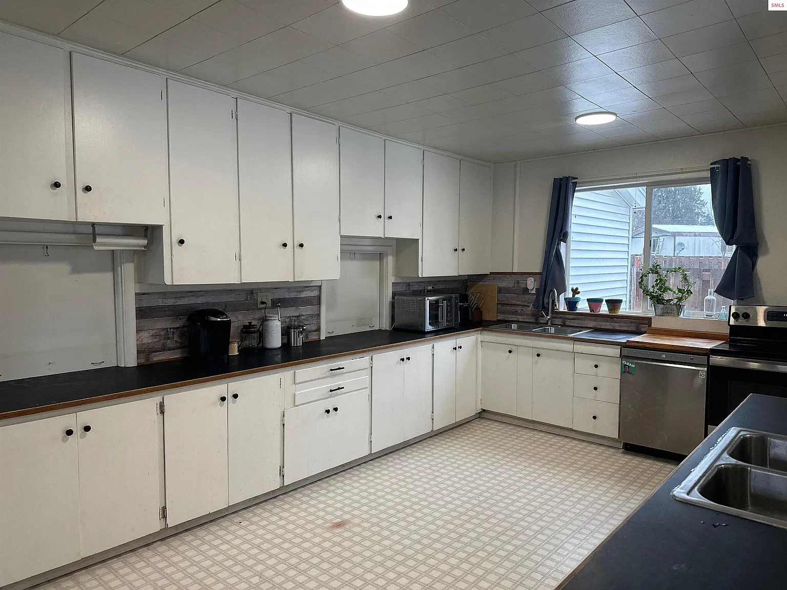 Here's the other kitchen—white cabinets, black tops, stainless. Classic rental look.
