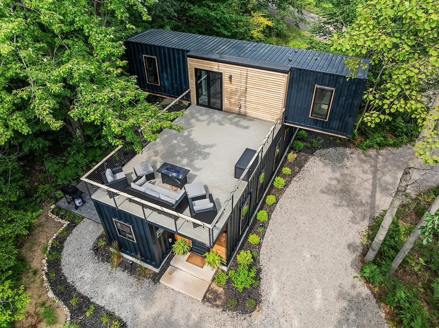 Back outside — corrugated blue with wood siding. Angles are boxy but balanced.